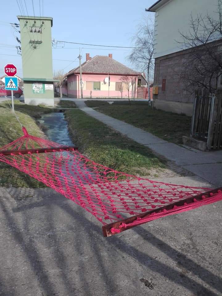 Crvena pletena viseća ležaljka u dvorištu